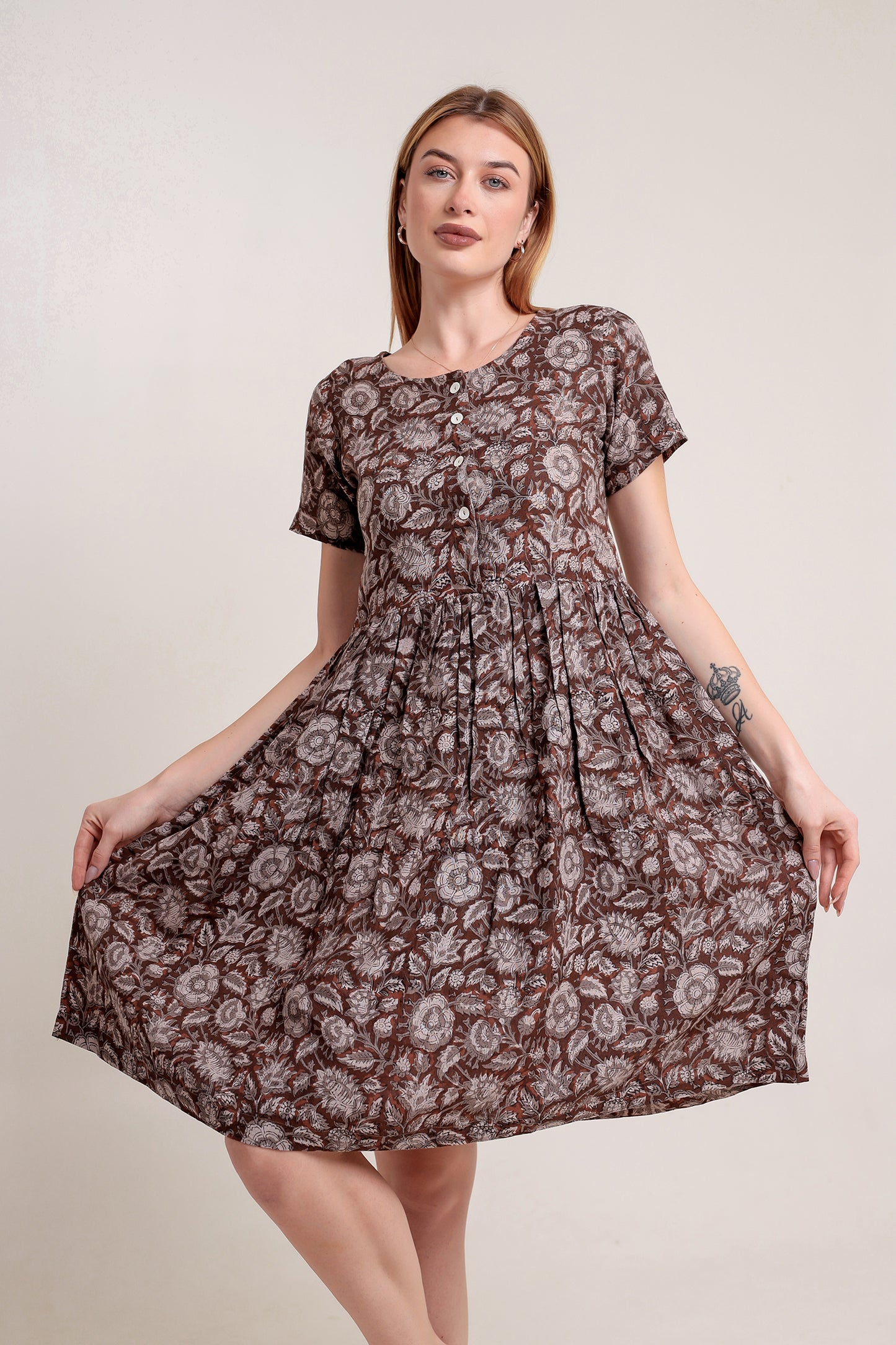 Woman wearing a brown floral linen mini dress against a plain background.