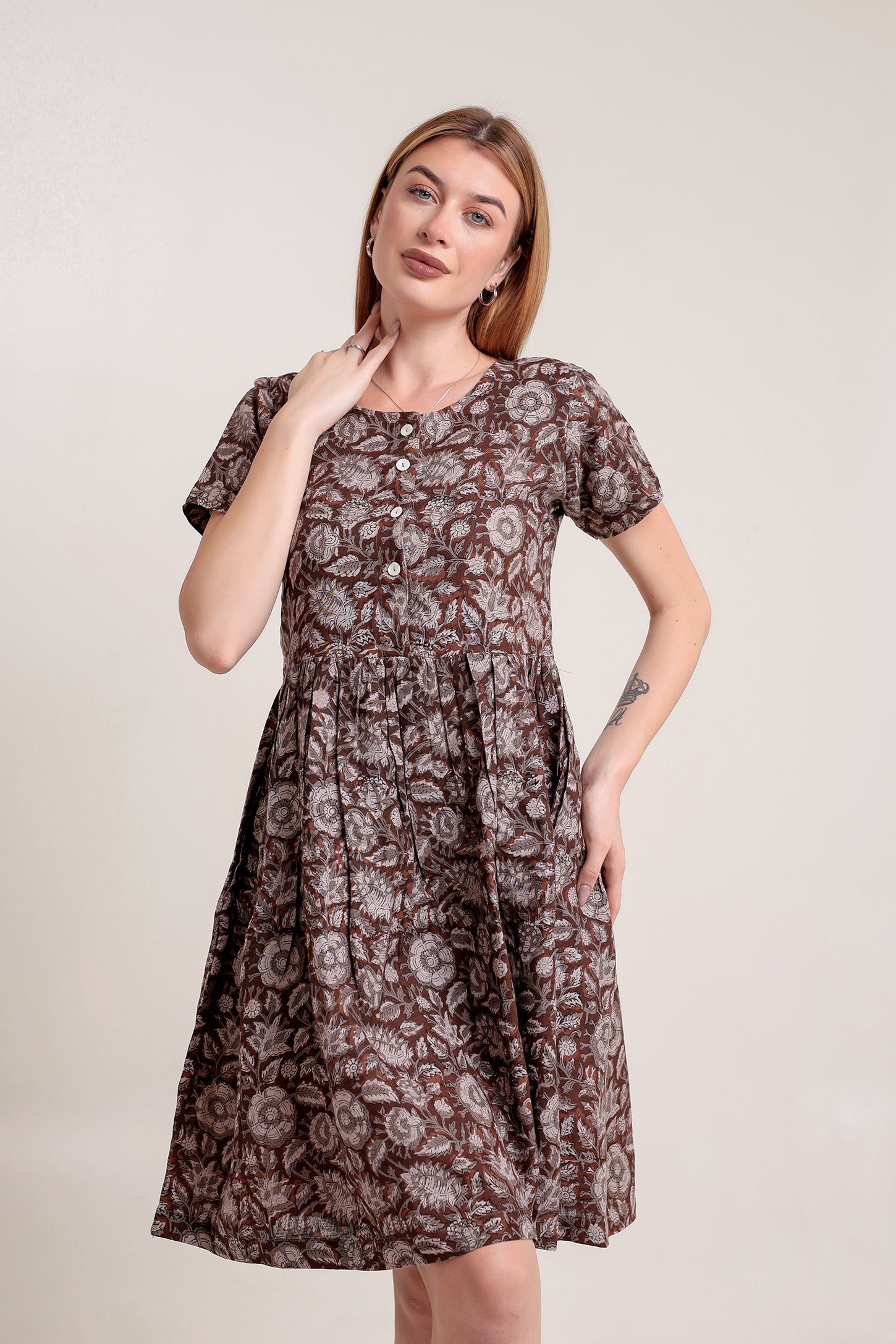 Woman wearing a brown floral linen mini dress against a plain background.