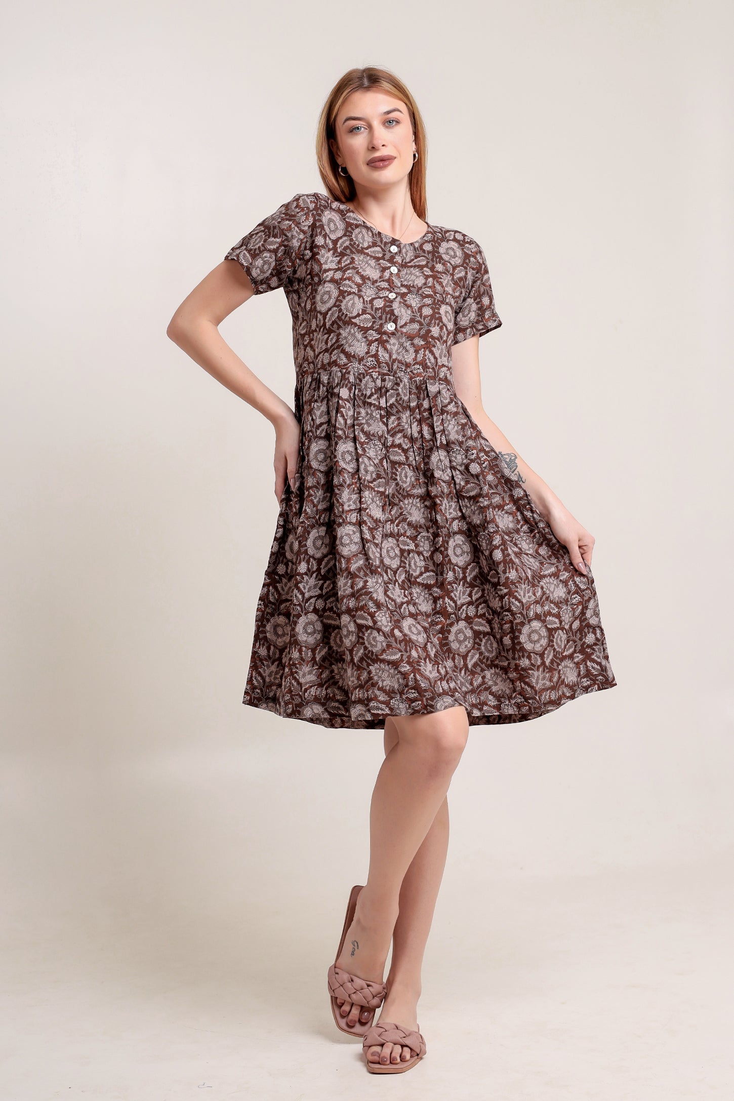 Woman wearing a brown floral linen mini dress against a plain background.