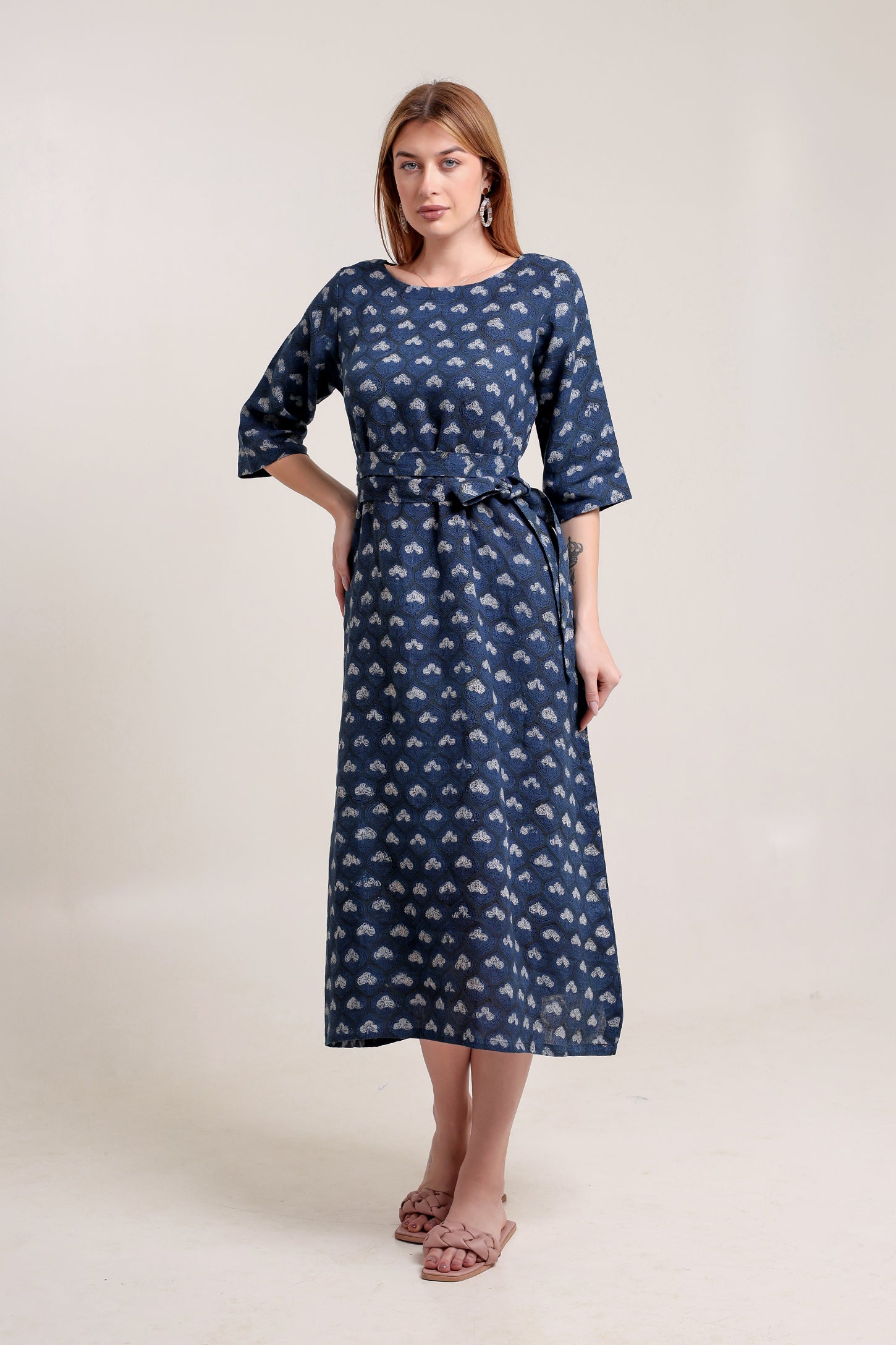 Woman wearing a blue patterned linen floral maxi dress against a white background.