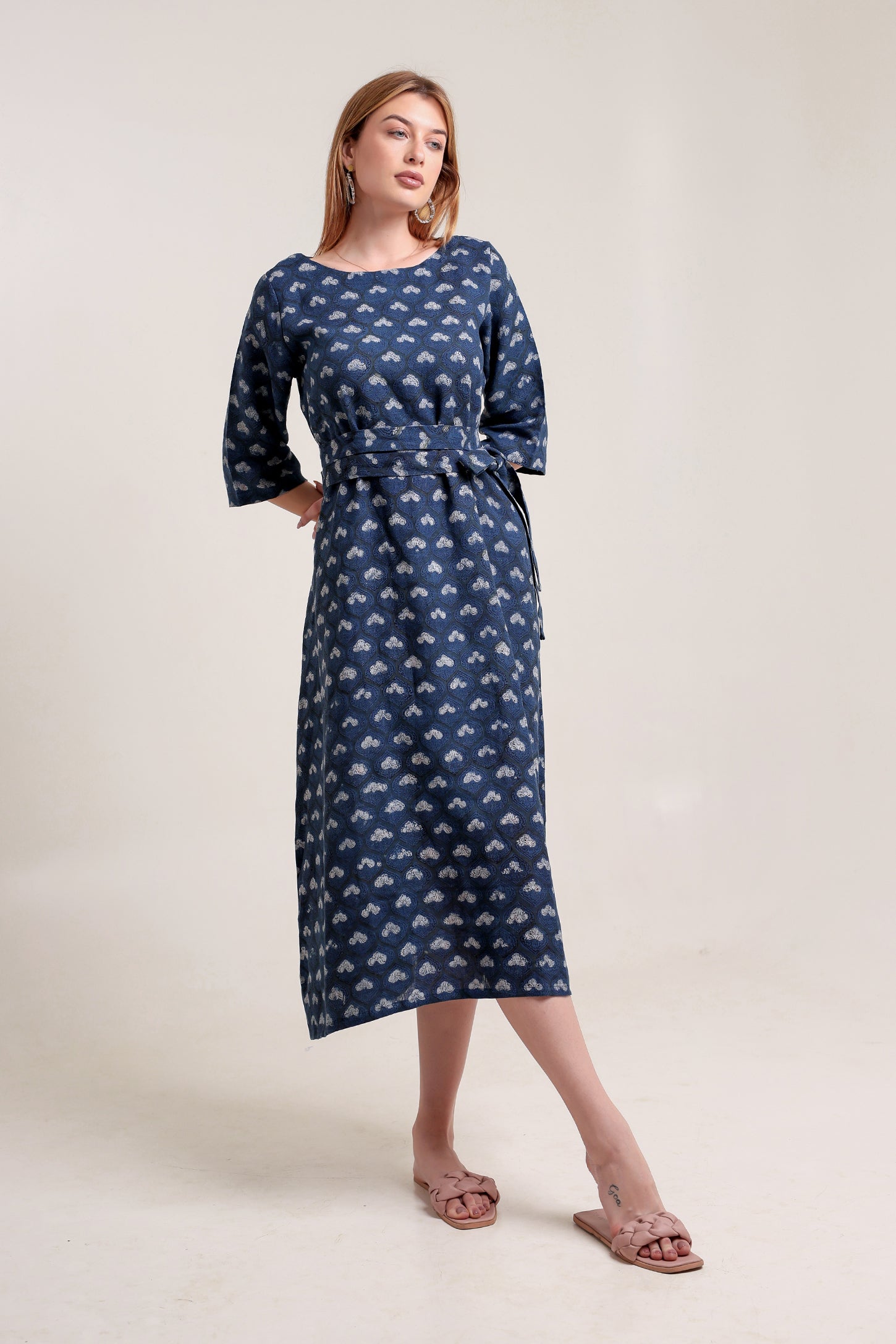 Woman wearing a blue patterned linen floral maxi dress against a white background.