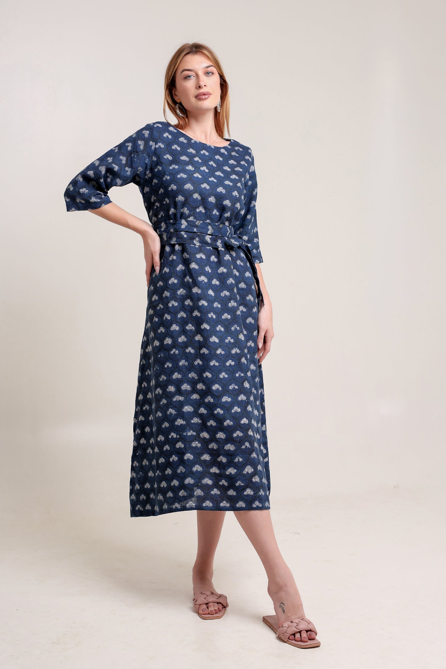 Woman wearing a blue patterned linen floral maxi dress against a white background.