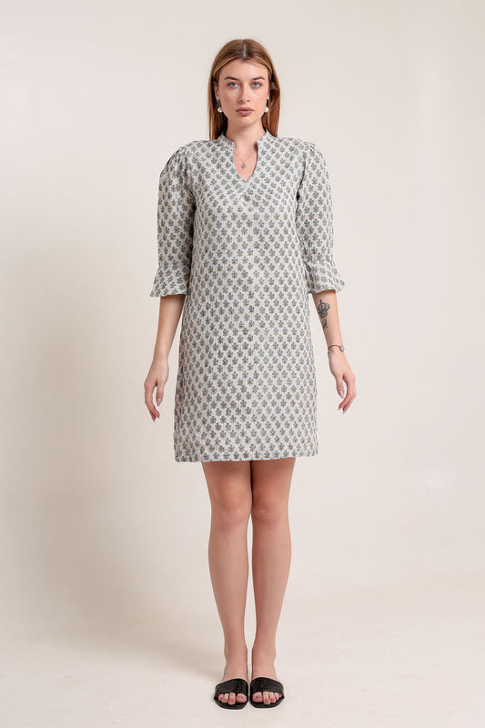 Woman wearing a patterned linen mini dress against a plain background.