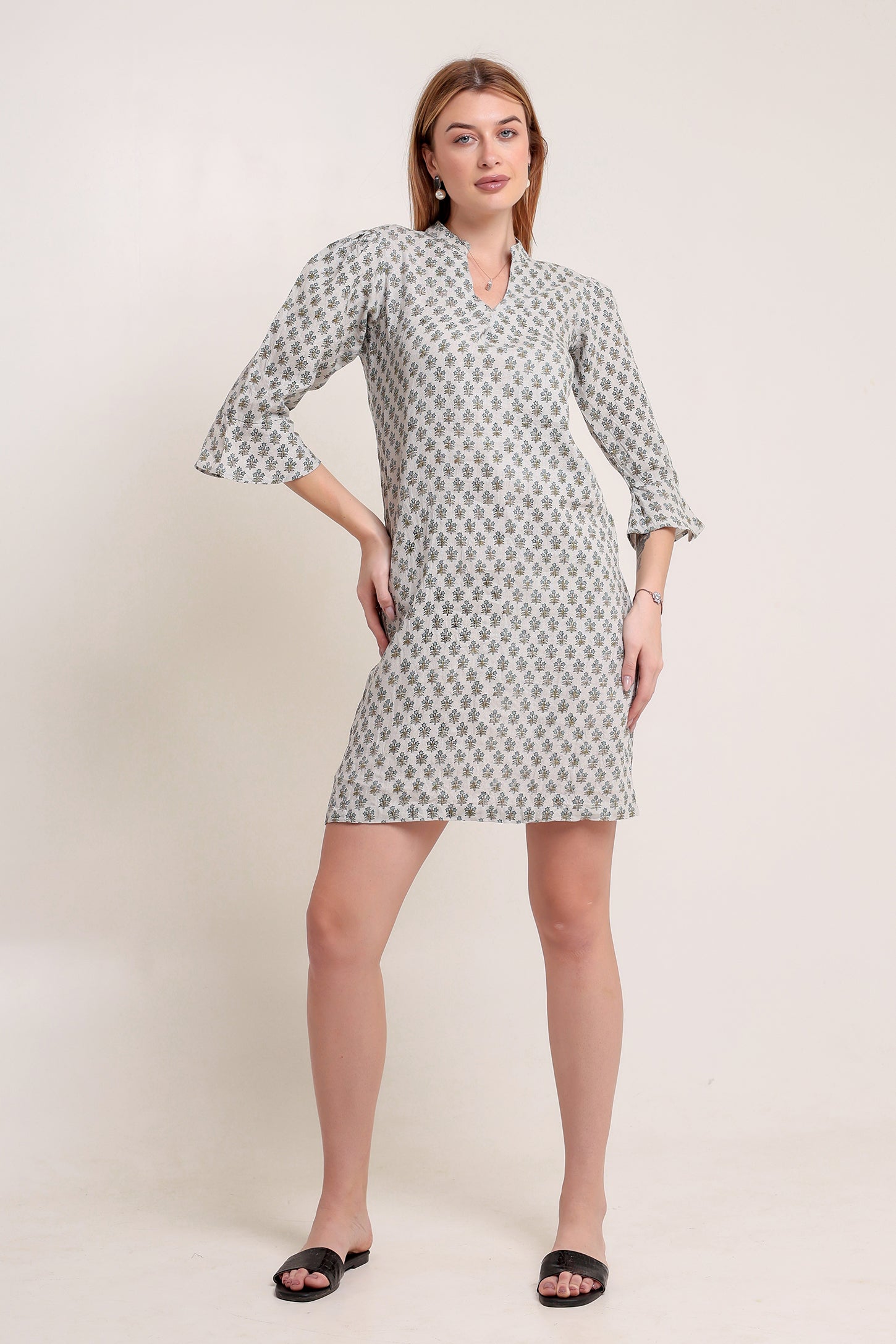 Woman wearing a patterned linen mini dress against a plain background.