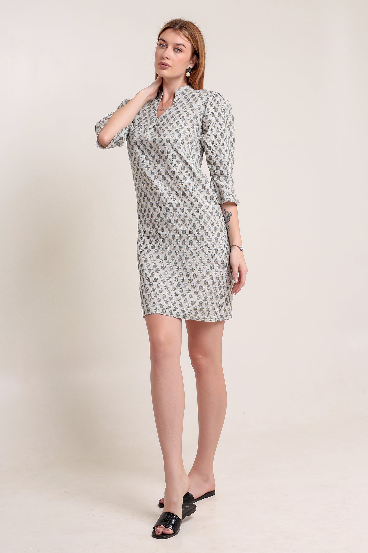 Woman wearing a patterned linen mini dress against a plain background.