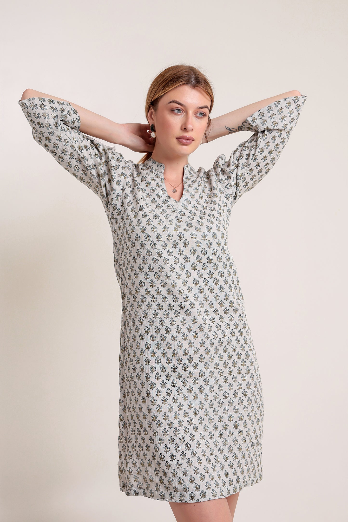 Woman wearing a patterned linen mini dress against a plain background.