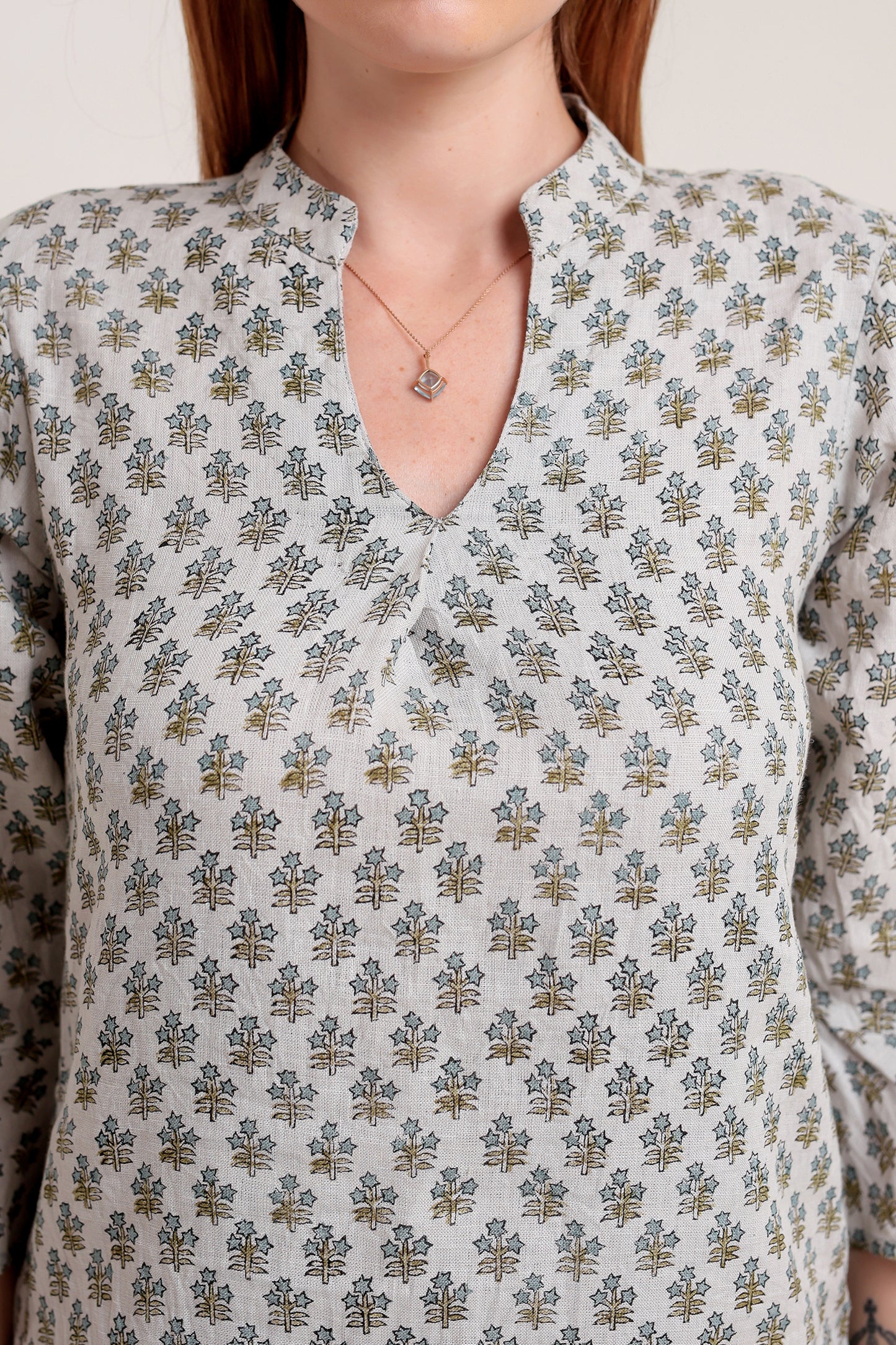 Person wearing a patterned linen mini dress against a neutral background.