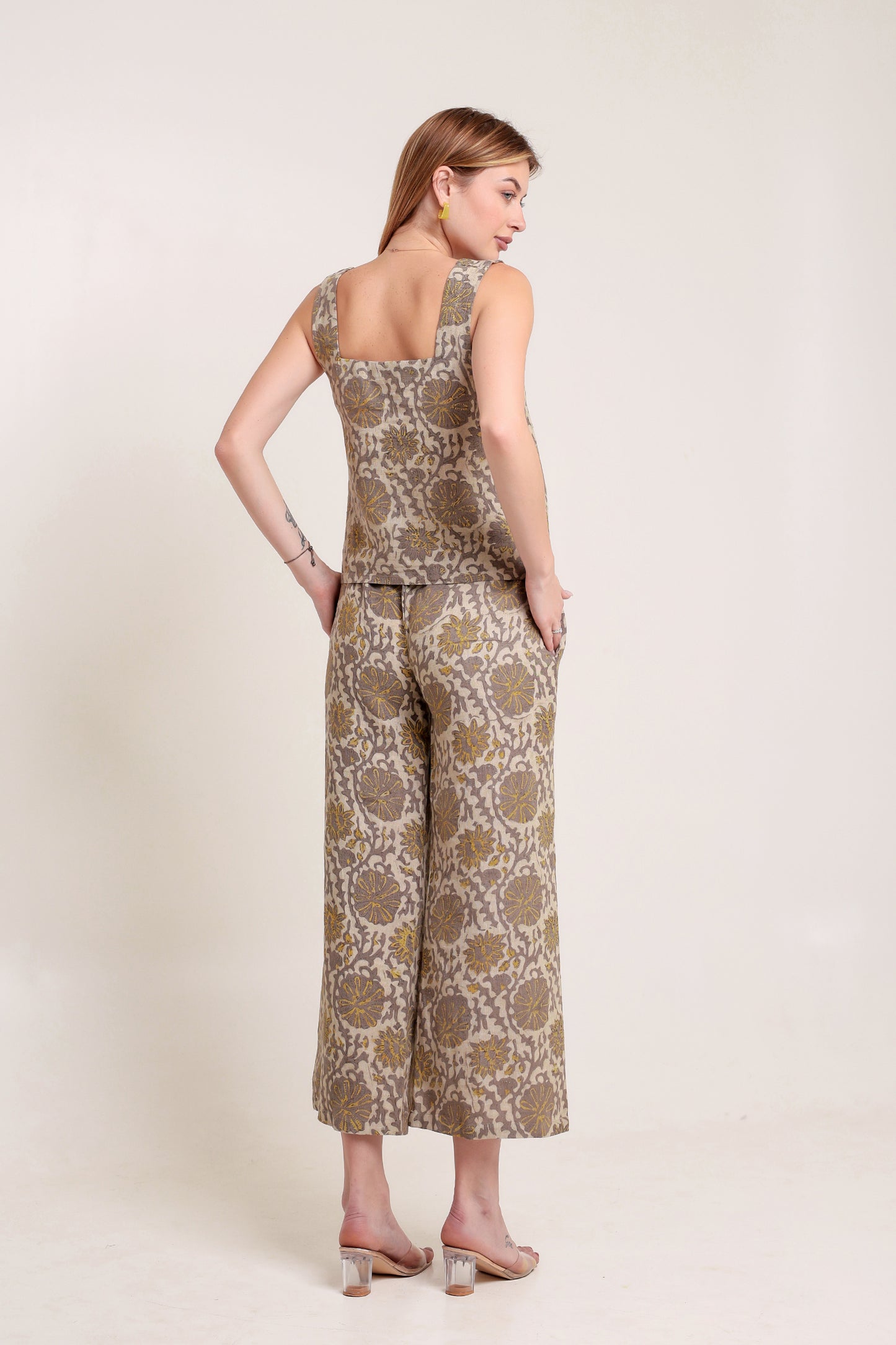 Woman wearing a patterned linen jumpsuit against a plain background.