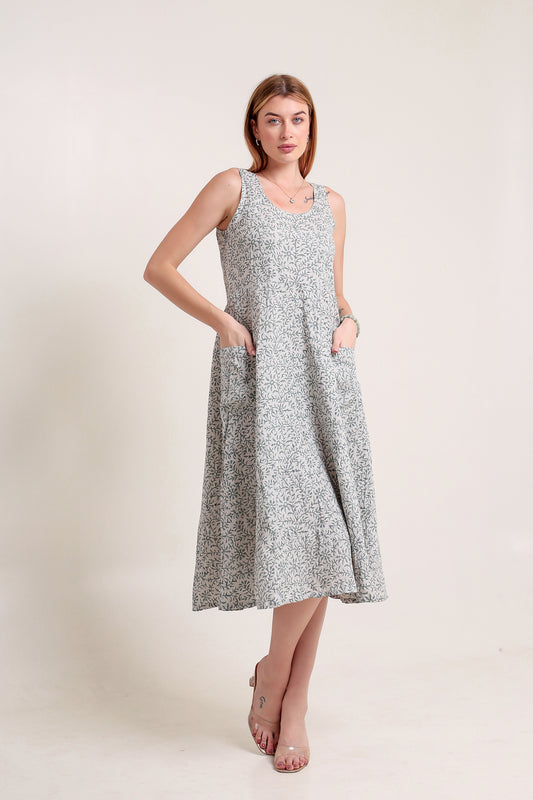 Woman wearing a gray floral linen floral maxi dress against a plain background.