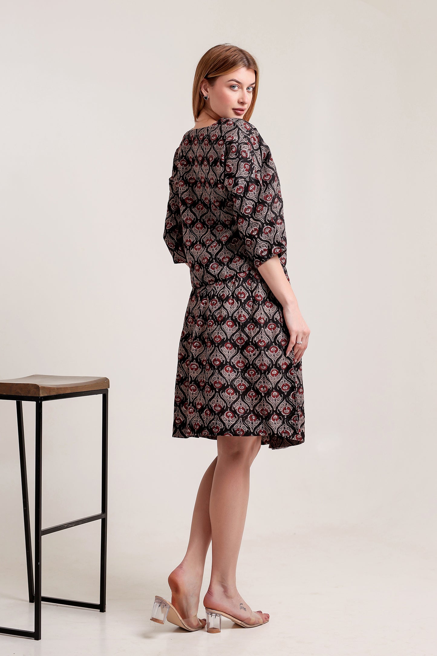 Woman wearing a chic linen midi dress, highlighting its light and breezy summer style.