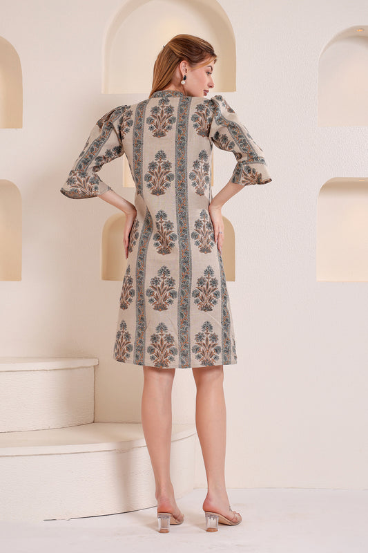 Woman wearing a patterned linen midi dress standing in an elegant interior setting.