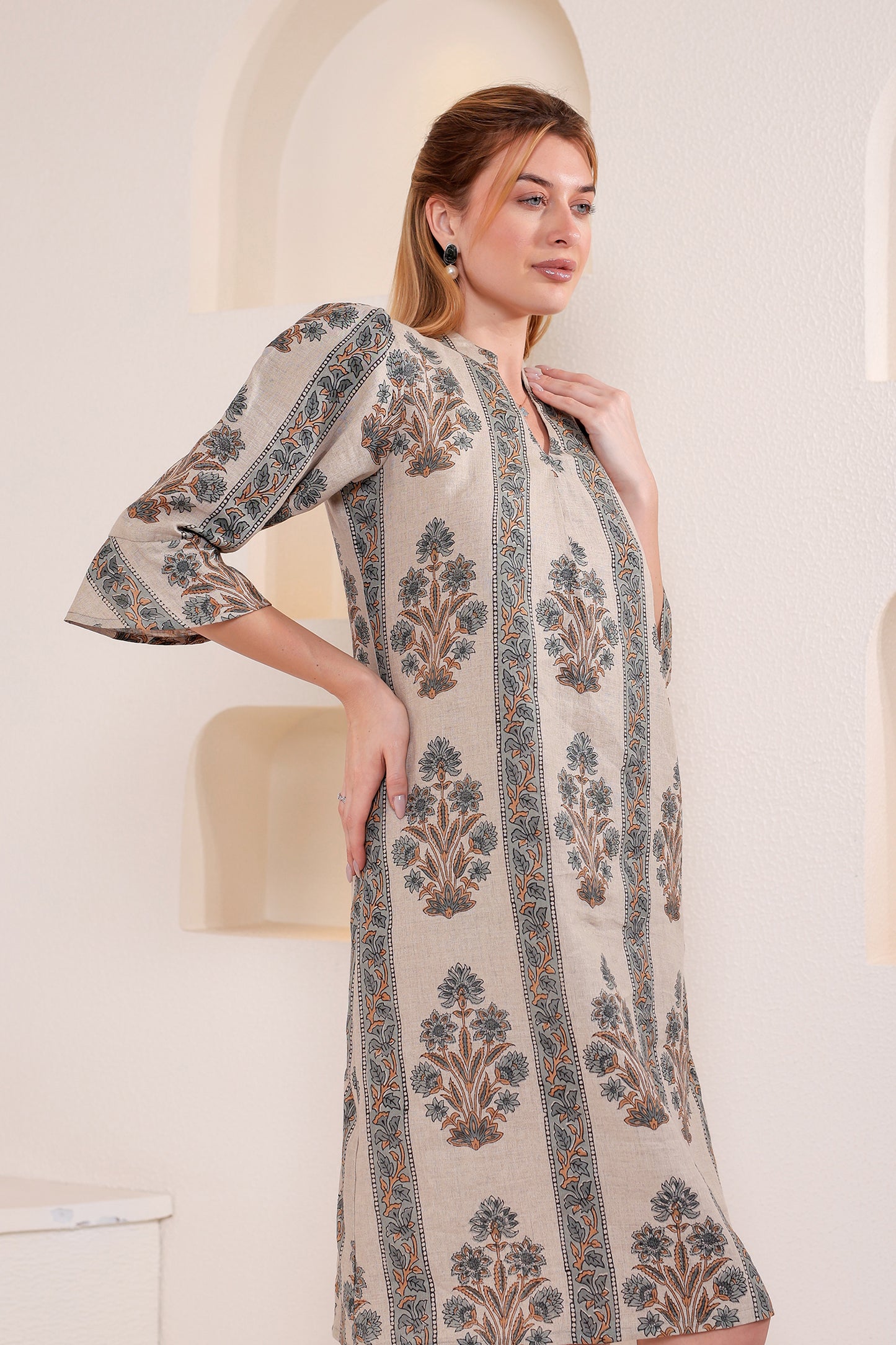 Woman wearing a patterned linen midi dress in an indoor setting.