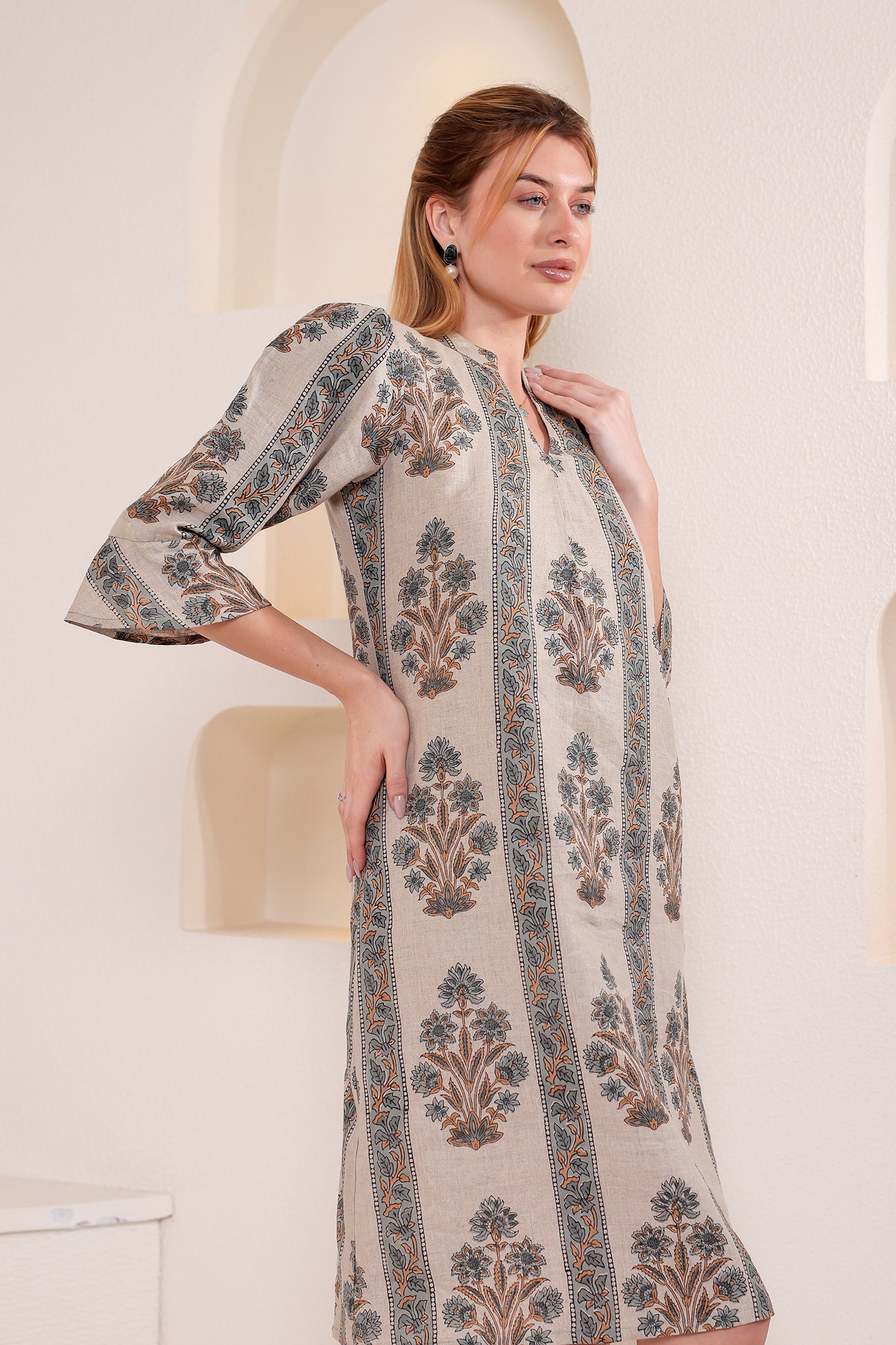 Woman wearing a patterned linen midi dress in an indoor setting.