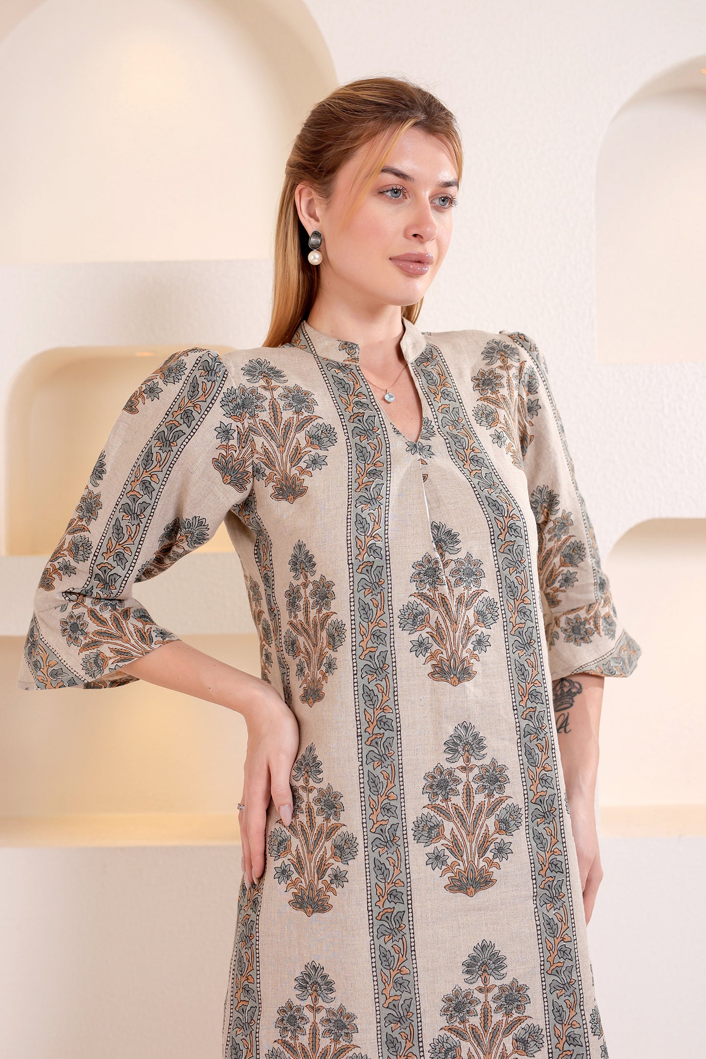 Woman wearing a patterned linen midi dress in an indoor setting.