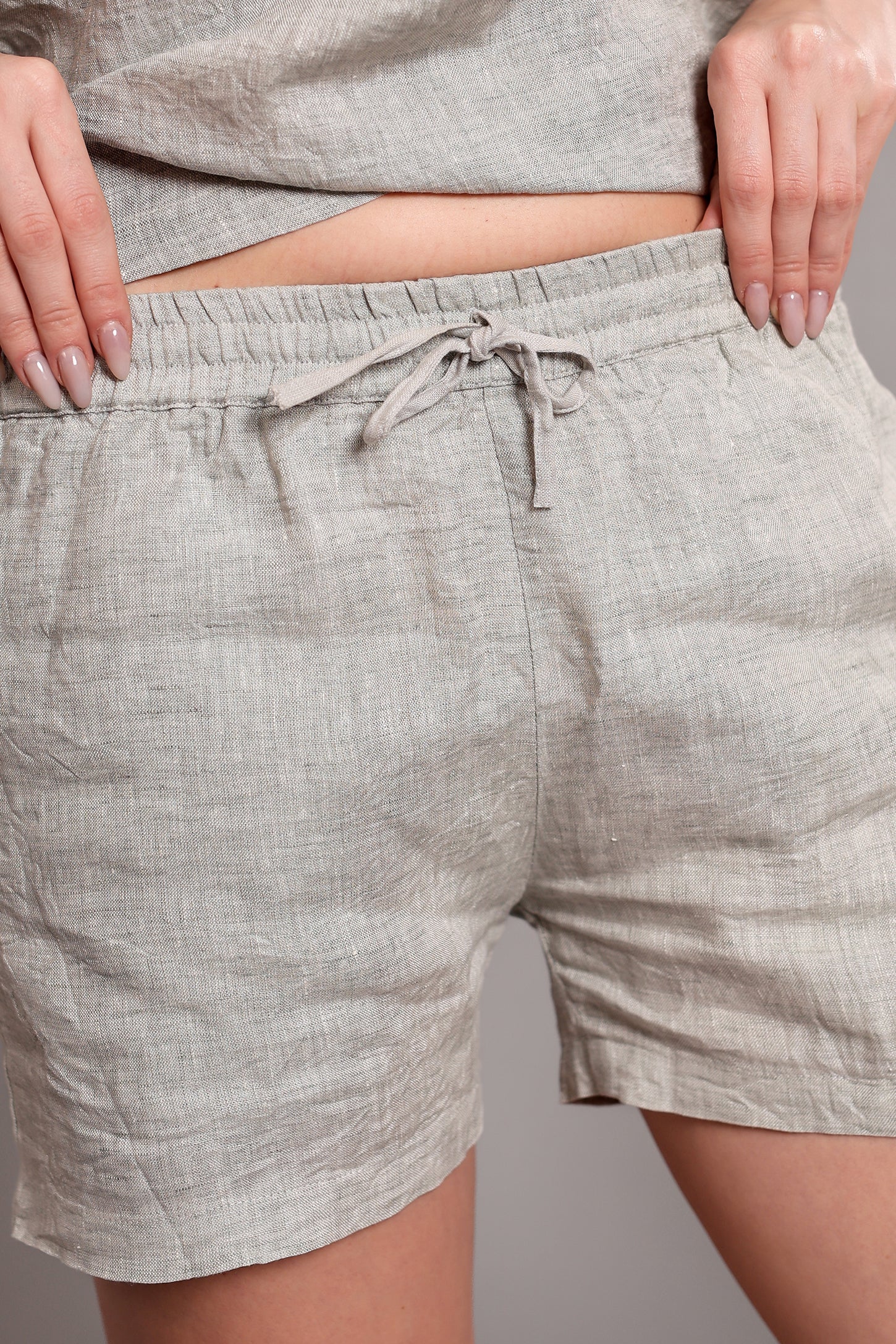 Gray linen shorts with a drawstring displayed against a neutral background.